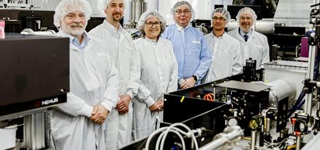 The collaborators on a project along side Donna Strickland stand by the laser