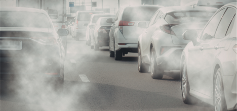 cars stuck in traffic with exhaust fumes floating in the air.
