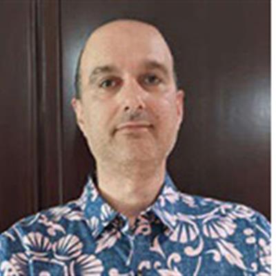 Prof. Gianluca Gregori smiling and wearing a patterned blue shirt