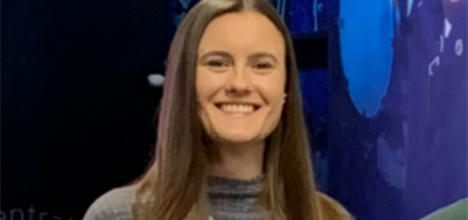 woman with brown hair beams at the camera