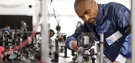 a CLF scientist wearing a blue lab coat works in Gemini laser