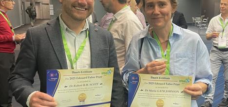 Robbie Scott (left) and the other prize winner Maria Gatu Johnson (right), holding their certificates and smiling at the camera