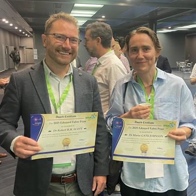 Robbie Scott (left) and the other prize winner Maria Gatu Johnson (right), holding their certificates and smiling at the camera