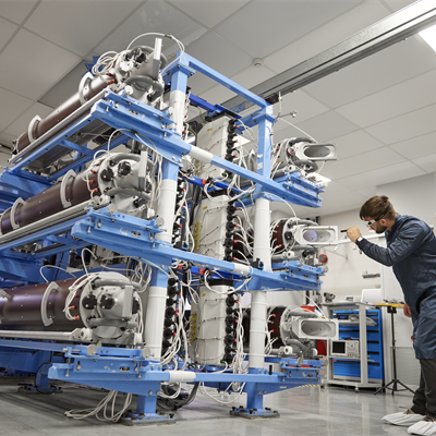 scientist inspects Vulcan's stack of 6 large laser amplifiers.