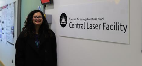Sneha standing next to a sign that reads "Science and Technology Facilities Council Central Laser Facility".