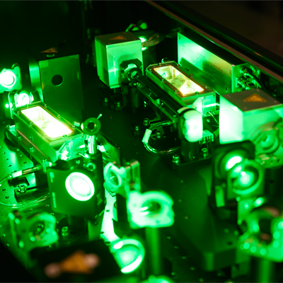 Optical elements on a workbench in Ultra with green glowing light representing the laser light. 