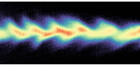 Multicoloured wave travelling across the image on a black background.